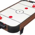 A foldable air hockey table stored upright in a clean, modern living room space.
