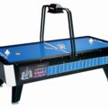 A modern air hockey table with a digital scorekeeper in a bright game room.