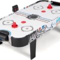 A modern LED air hockey table glowing in a stylish residential game room.