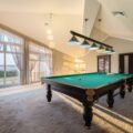 Pool table centered in a bright room showing the space needed